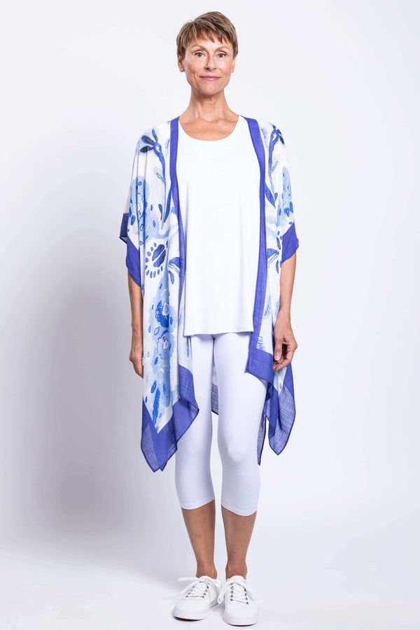 Full front view of woman in blue floral Darcy kimono wrap with white leggings
