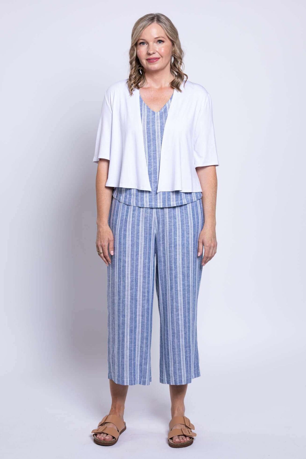Full view of model in Landon Capri Pants, blue stripe set, and white cardigan