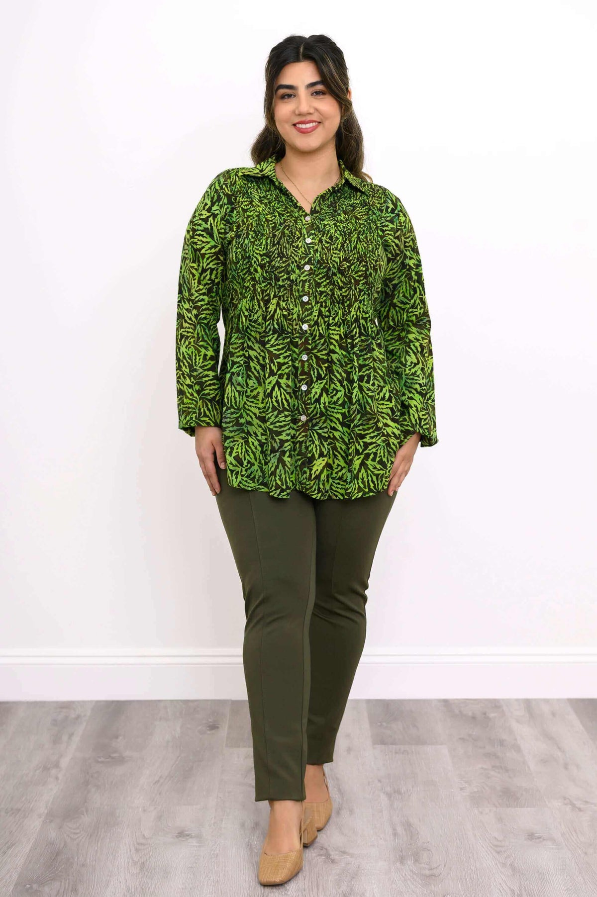 Model wearing green leaf print smocked shirt with olive pants, full length view