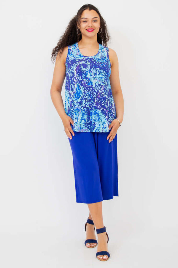 Full body view of woman in a blue paisley bamboo tank top with wide blue pants