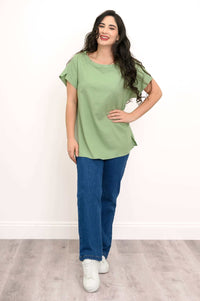 Full view of a woman in a sage green relaxed fit tee paired with blue jeans and white sneakers