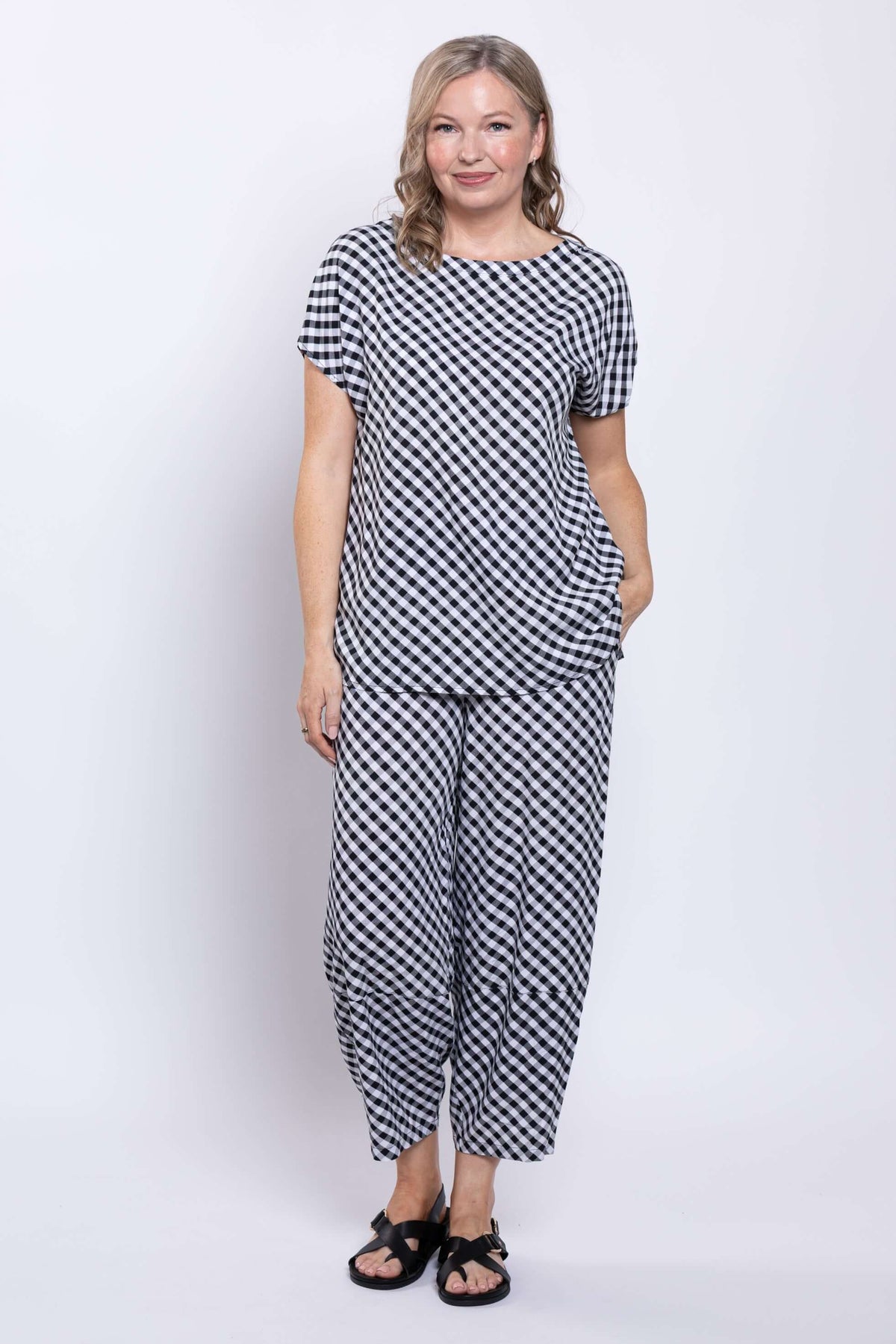 Full body view of a woman modeling a gingham linen blend top and matching pants