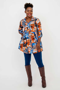 Full body shot of woman in Van Gogh art print tunic, blue leggings, and brown boots