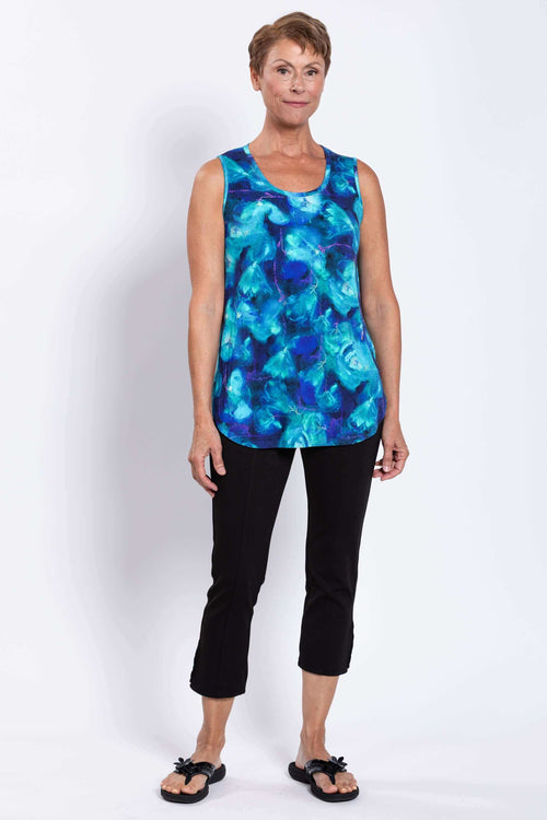 Woman in full view wearing a blue watercolor-patterned sleeveless bamboo tank and black pants
