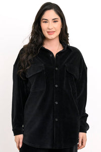 Front view of a woman wearing a black button-up corduroy shirt jacket with double flap pockets