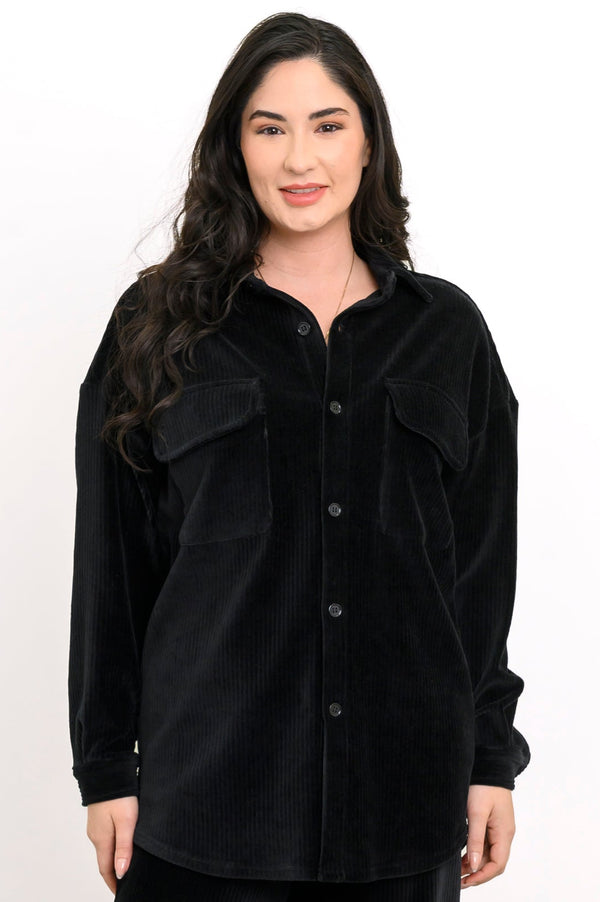 Front view of a woman wearing a black button-up corduroy shirt jacket with double flap pockets