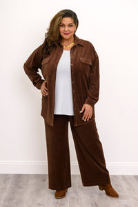 Full-length front view of a woman wearing an open dark brown corduroy shirt jacket with matching wide-leg trousers