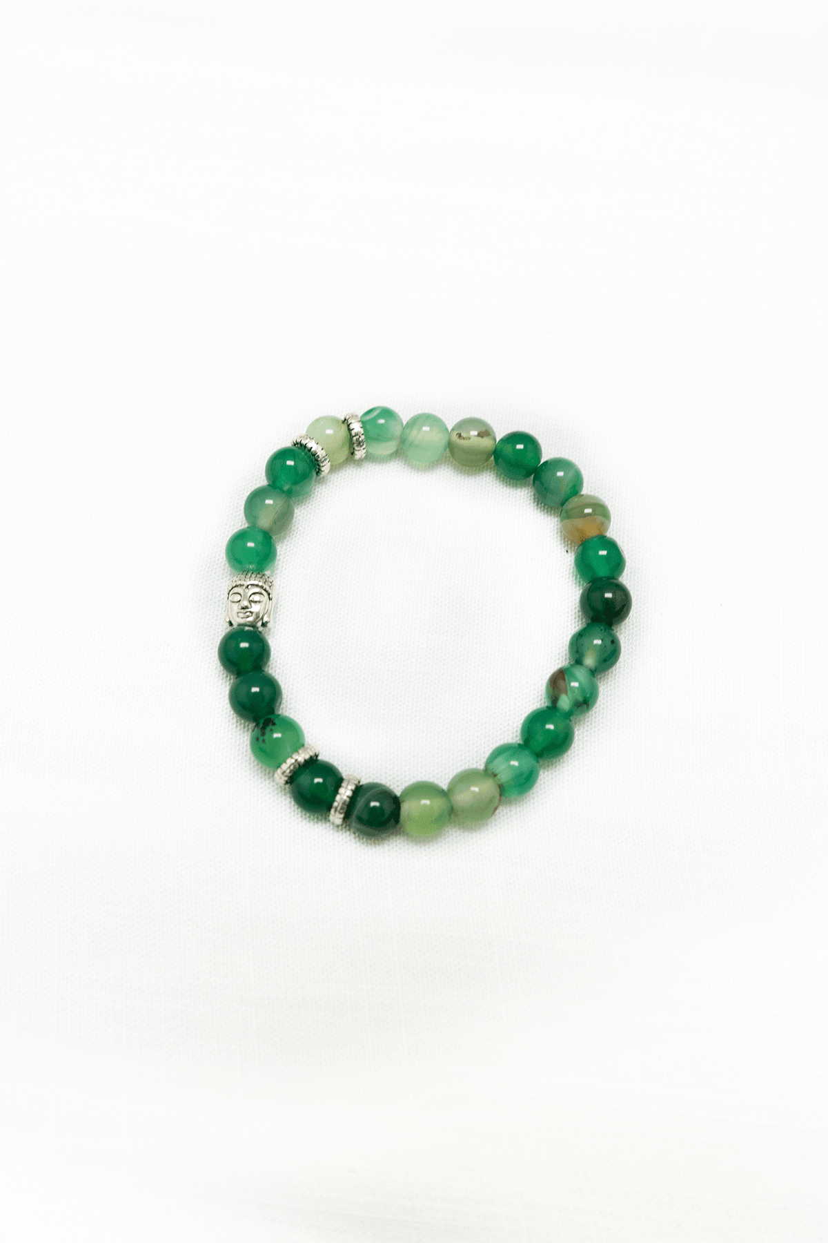Green agate beaded bracelet with silver Buddha charm and spacers on a white background