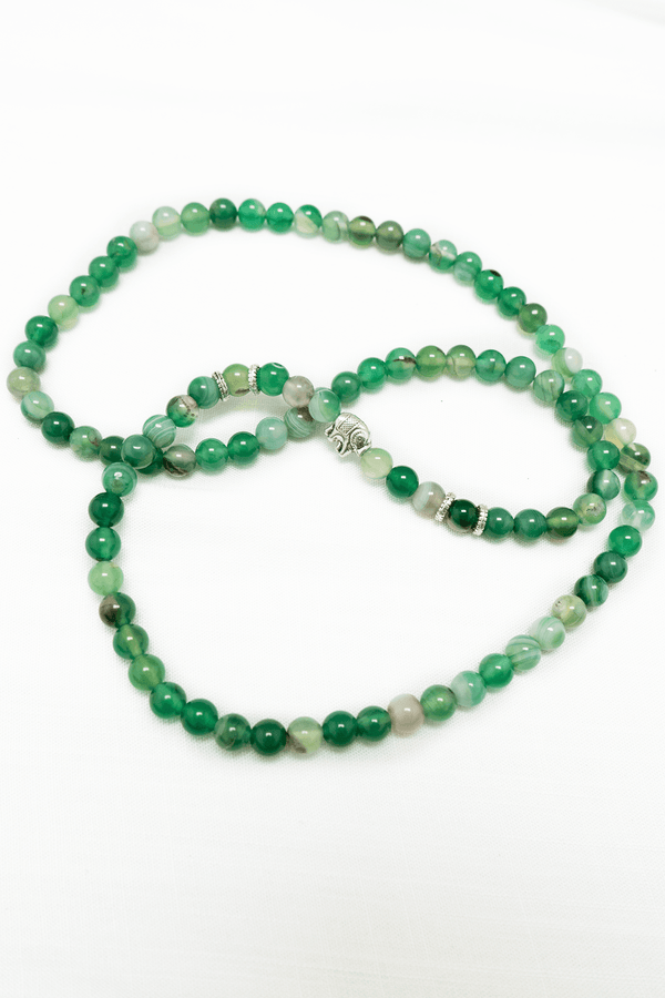 Green aventurine beaded necklace with silver accent beads displayed on a white background