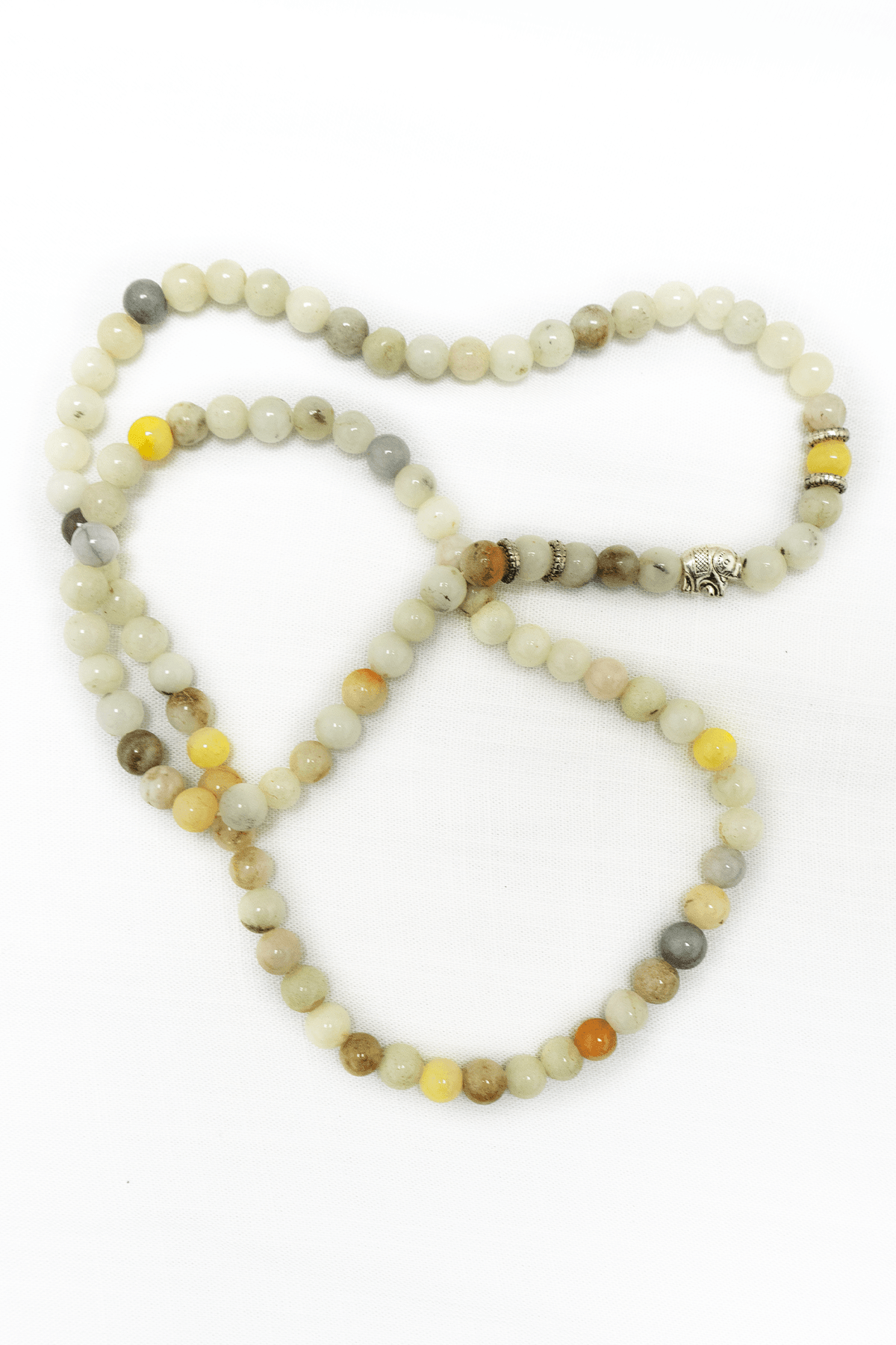 Handcrafted jade mala necklace with natural jade beads and silver accent, displayed on a white background