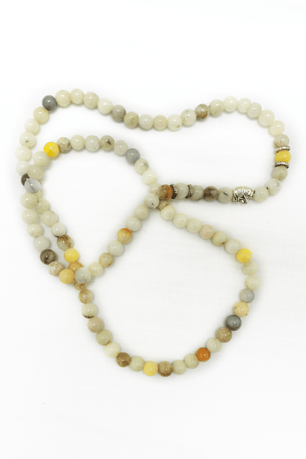 Handcrafted jade mala necklace with natural jade beads and silver accent, displayed on a white background