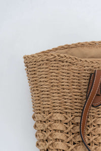Detail of the woven texture and handle attachment on the left side of the tote bag