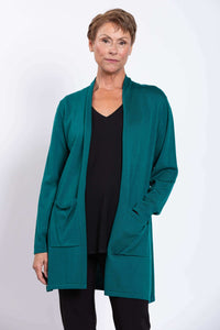 Woman with hands in pockets, modeling teal Paige Sweater cardigan