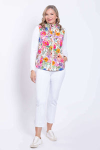Woman modeling a pink floral print vest and white pants, facing forward