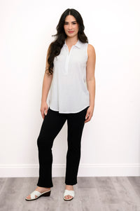 full body front view of woman wearing white zippered tank top, slim black pants, and white shoes