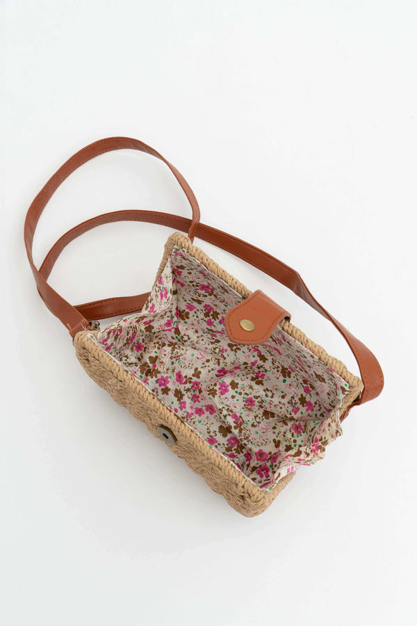 Interior of handbag with floral lining and brown faux leather strap