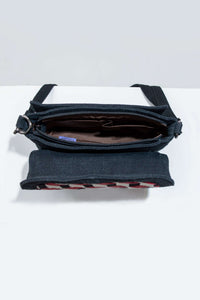 Interior view of black crossbody bag, showing zippered pocket and lining