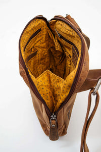 Interior view of vintage bag, showing yellow patterned lining and zipped pockets