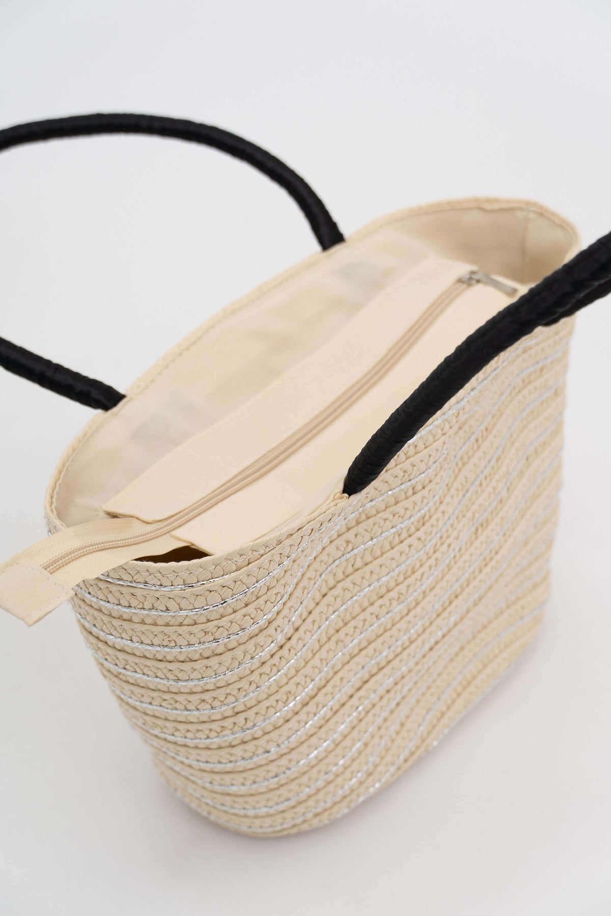 Open woven tote bag highlighting interior lining and zippered closure