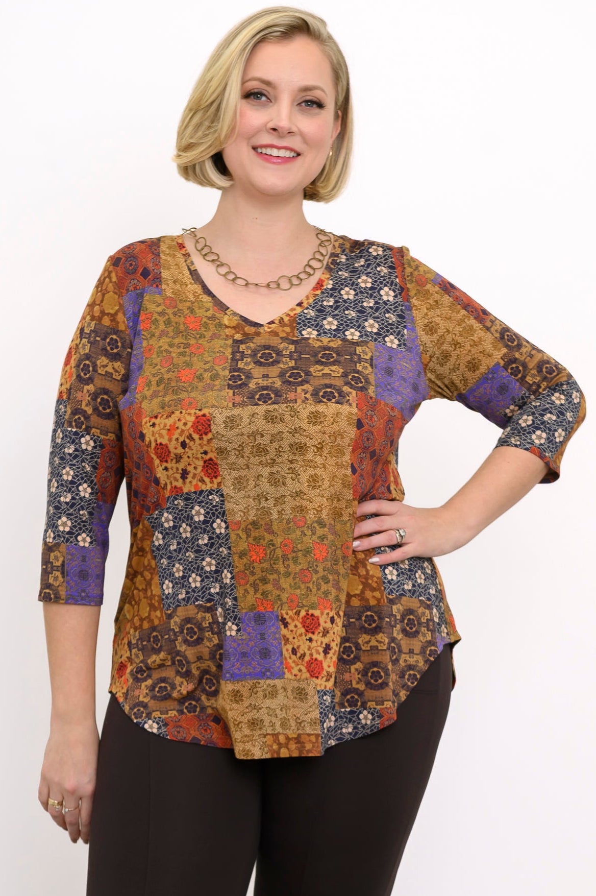 Yellow patchwork bamboo V-neck top with 3/4 sleeves, styled with brown trousers against a white background.