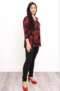 Side-facing view of a black and red floral print knit tunic, highlighting its comfortable, straight hemline.