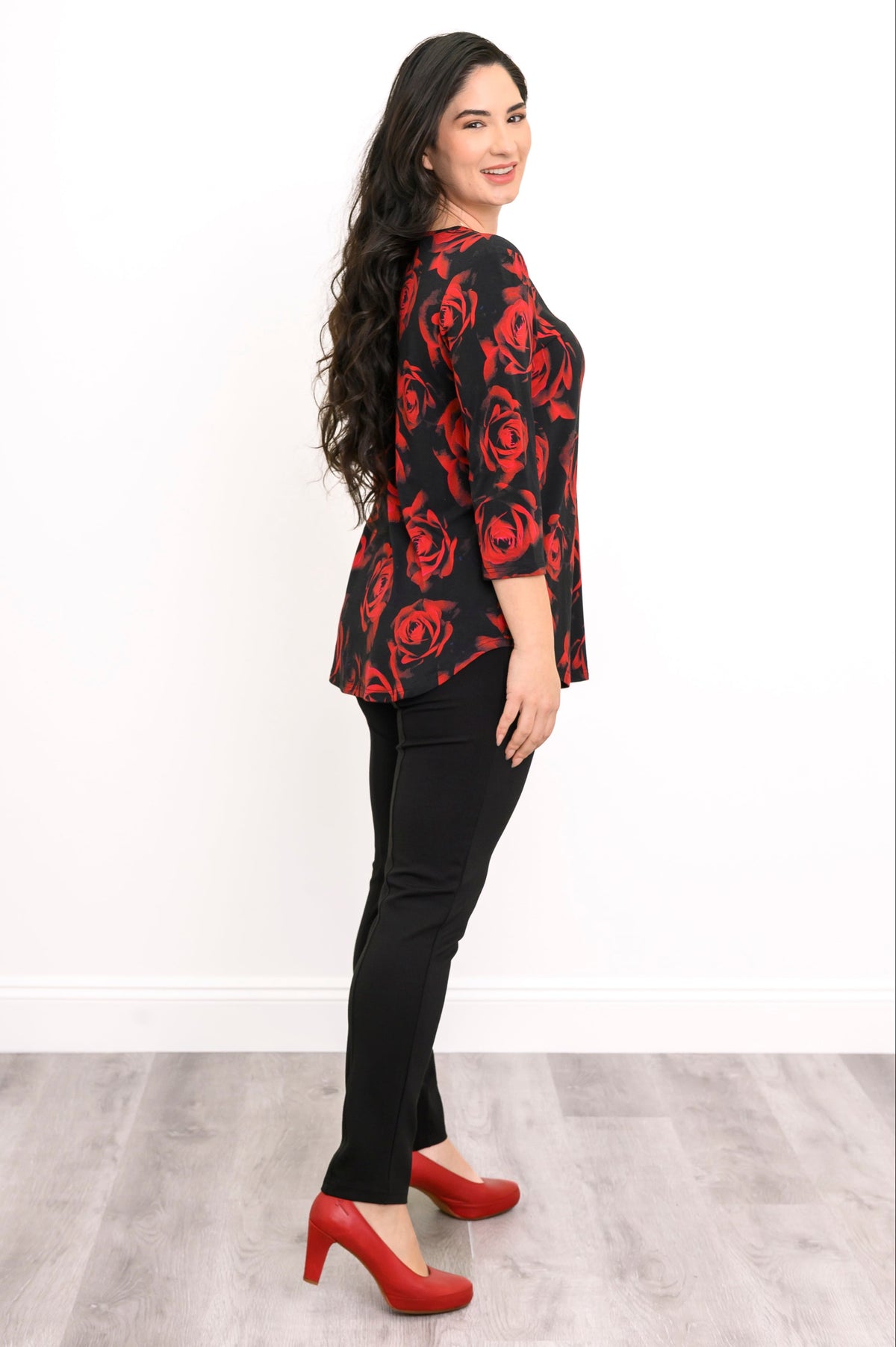 Profile view of a red rose print bamboo top on a model, showcasing the relaxed fit around the midsection.