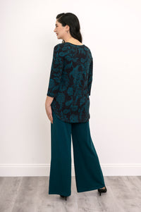 Rear view of a coordinating teal leaf print knit set, highlighting the straight back hem of the 3/4 sleeve top.