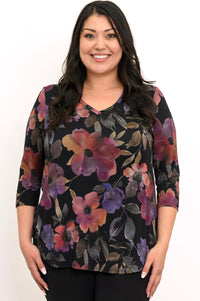 Smiling woman wearing a plum-pink botanical print bamboo top with a soft V-neck and 3/4 sleeves, front view.