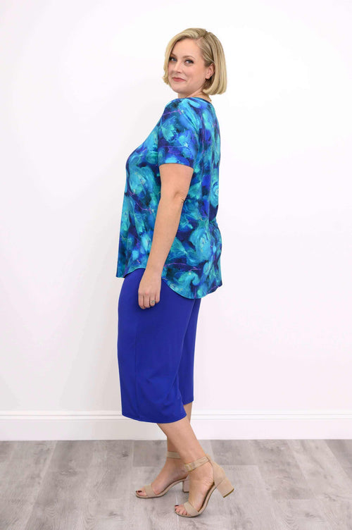 Side view of model in Jackie Bamboo V-Neck Top Water Lily with royal blue pants