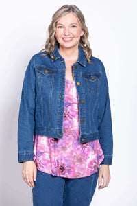 Woman layering denim jacket over pink and purple floral bamboo top
