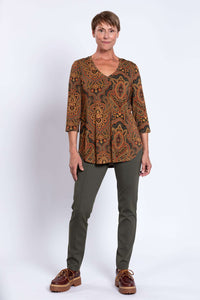 Full front pose of woman in Jackie V-neck bamboo top, green pants, and brown shoes