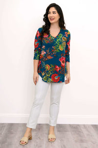 Woman smiling, wearing Jackie V Neck teal floral bamboo top, hands at her sides
