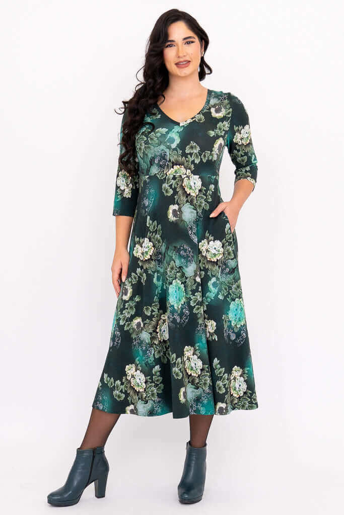 Woman modeling a jade green floral midi dress with V-neck and three-quarter sleeves