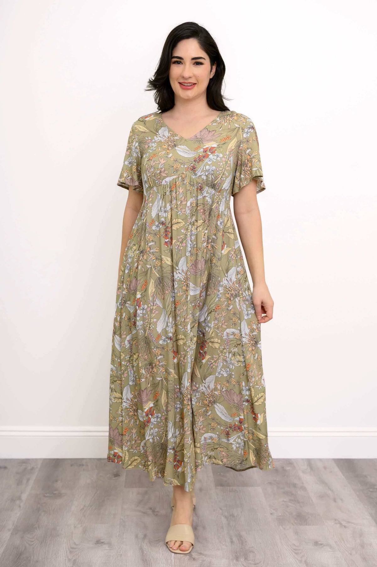 Woman in green floral Jane empire waist maxi dress standing straight