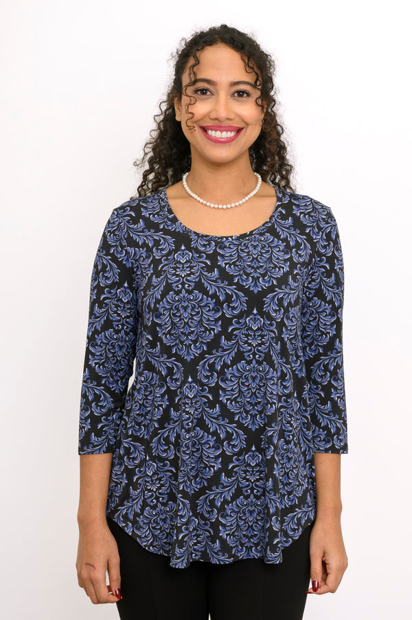 Close-up of a blue patterned scoop neck top highlighting the fitted shoulders and drape of the fabric.