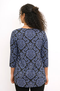 Back view of a woman wearing an indigo patterned 3/4 sleeve bamboo top with a clean shoulder fit.