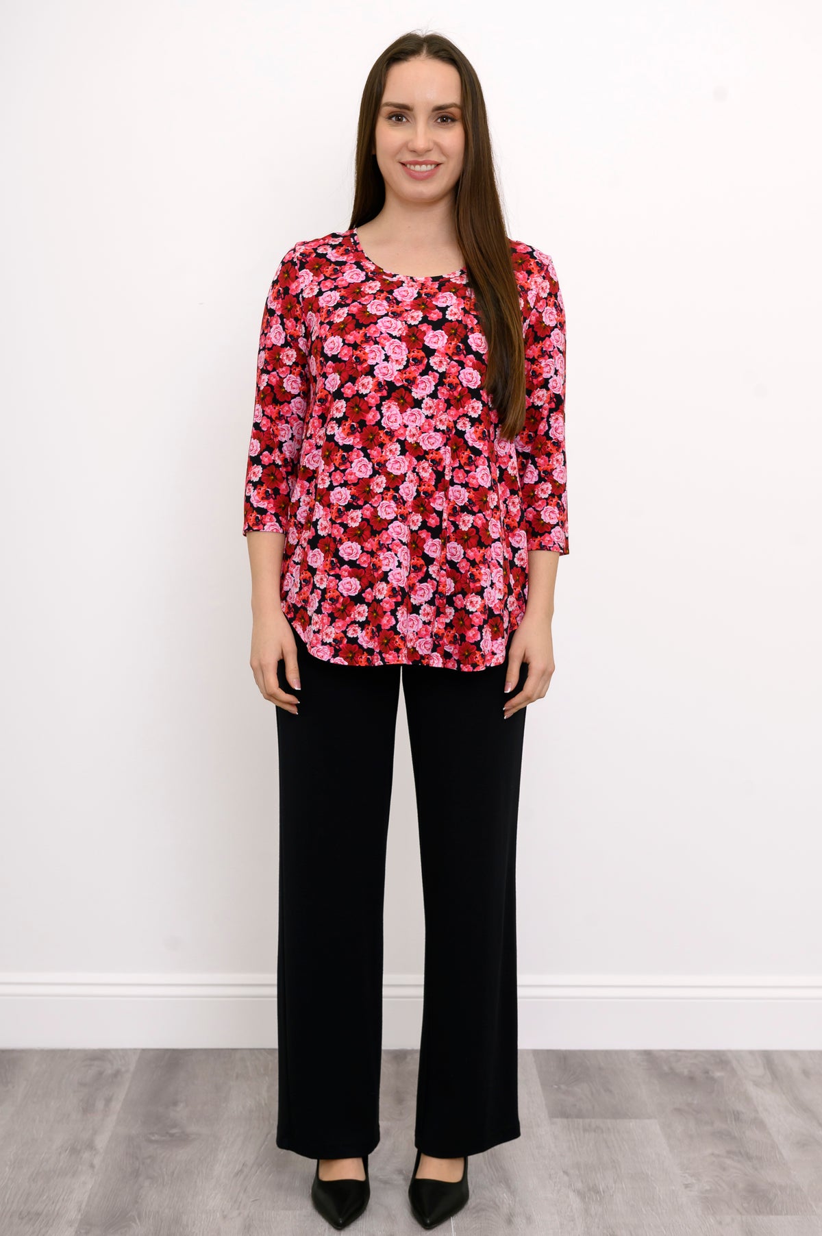 Model posing hand-on-hip in a red and pink flower print bamboo top, showcasing a comfortable, fluid silhouette.