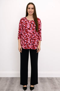 Model posing hand-on-hip in a red and pink flower print bamboo top, showcasing a comfortable, fluid silhouette.