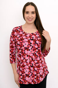 Smiling woman wearing a pink and red floral print bamboo top with three-quarter sleeves and a round neck, front view.