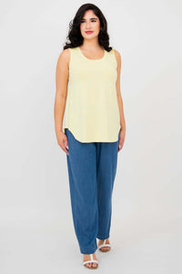 Woman standing in lemon yellow tank top and blue wide-leg pants, front angle