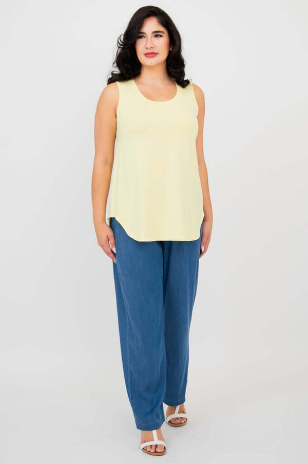 Woman standing in lemon yellow tank top and blue wide-leg pants, front angle