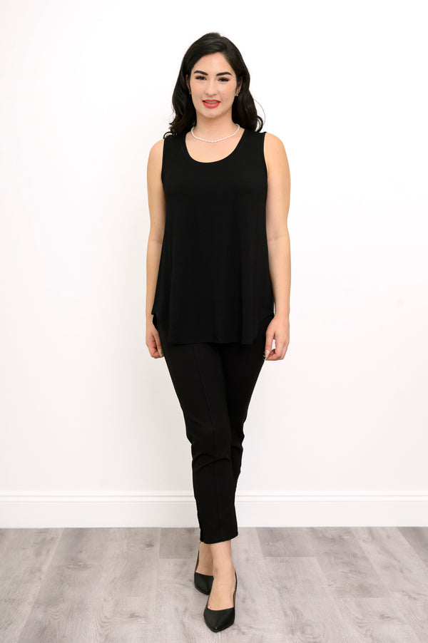 Woman wearing a black sleeveless top and black pants against a white background, front view