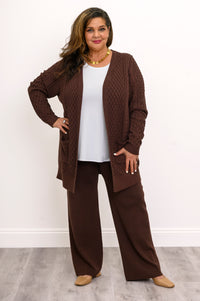 Hip length dark brown open front cardigan styled with a monochrome earth tone trousers outfit.