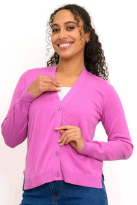 Woman wearing a pink button-up V-neck cardigan with ribbed cuffs and hem, smiling