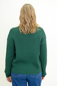 Back view of a women's long-sleeve dark green knit top, styled with blue jeans against a white backdrop.