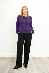 Front view of a vibrant amethyst knit top and black trousers, highlighting a comfortable, relaxed silhouette.