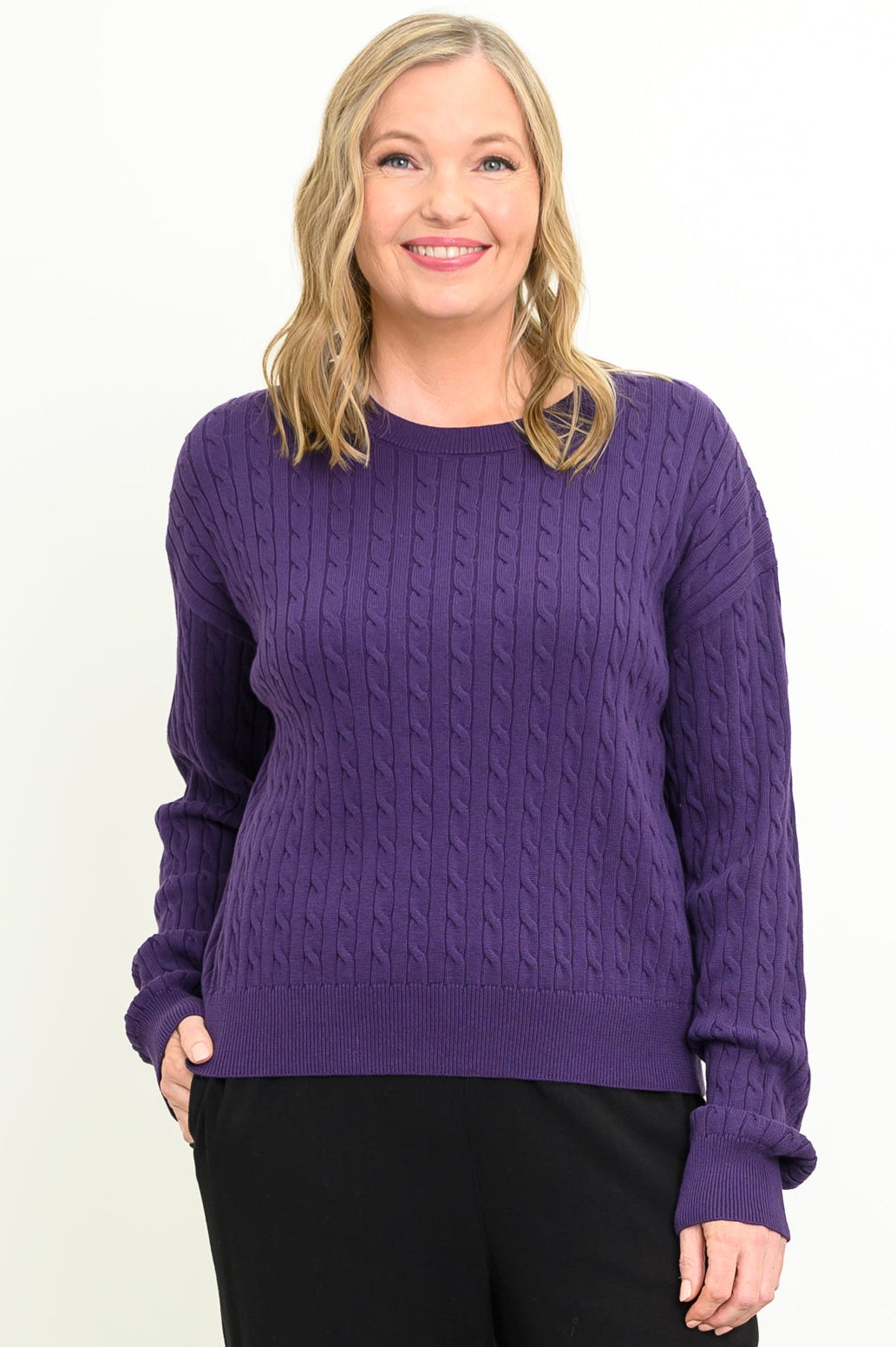 Women's long-sleeve knit top in a vibrant amethyst hue with a round neck, styled against a white backdrop.