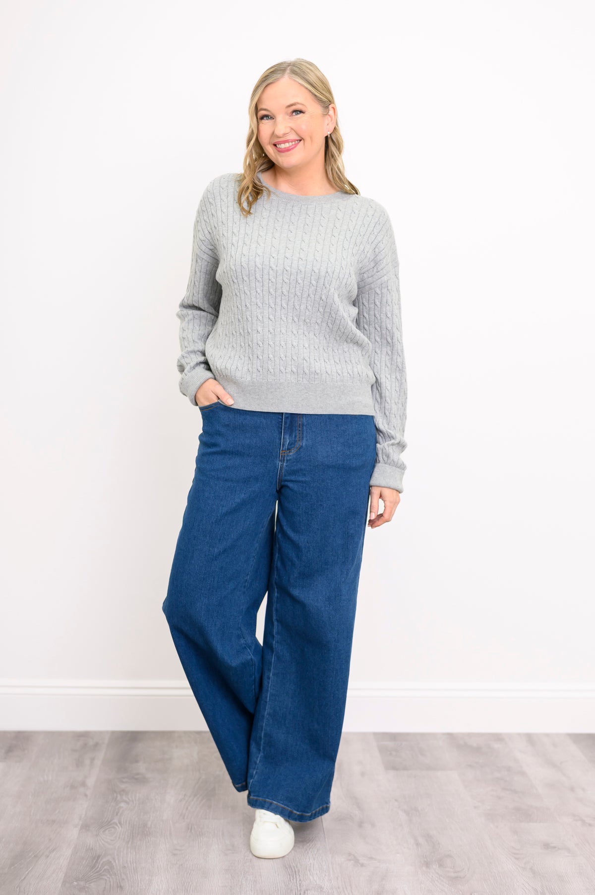 Front view of a pale silver knit top and denim pants, highlighting a comfortable and relaxed silhouette.