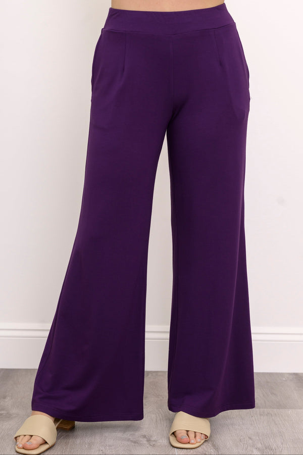 Front view of a woman wearing royale purple wide-leg bamboo French terry pants with front darts.