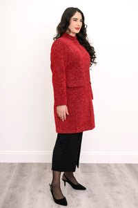 Side view of woman wearing long red coat with mandarin collar and flap pockets